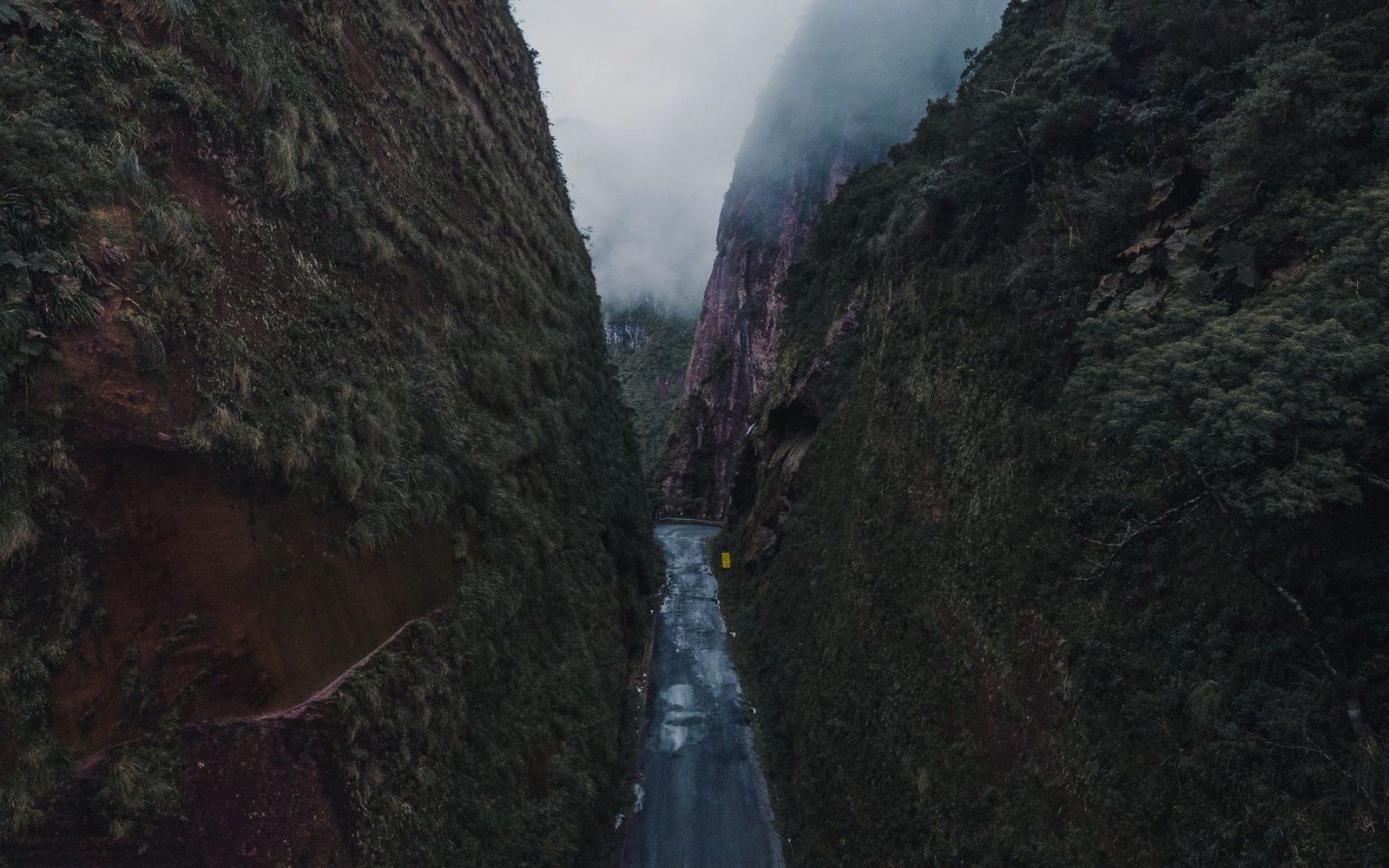 Narrow mountain gorge road rail competing ledge aerial
