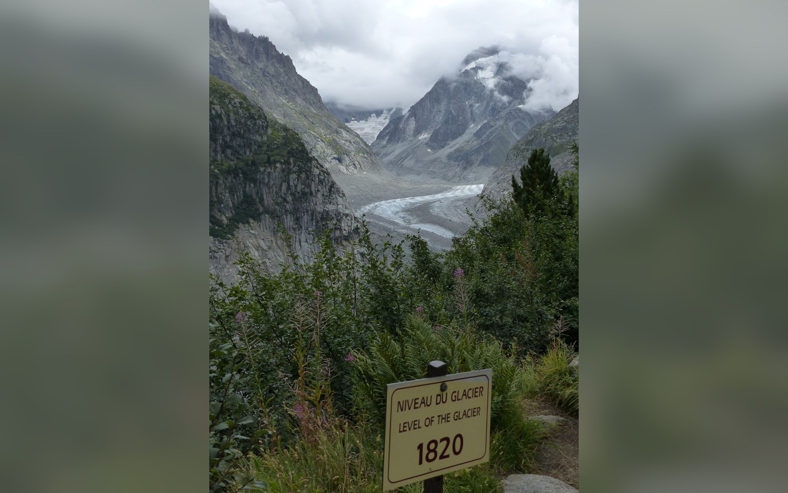 The Mer de Glace glacier face with painted altitude markers on the rock showing its measured retreat since the 1820s